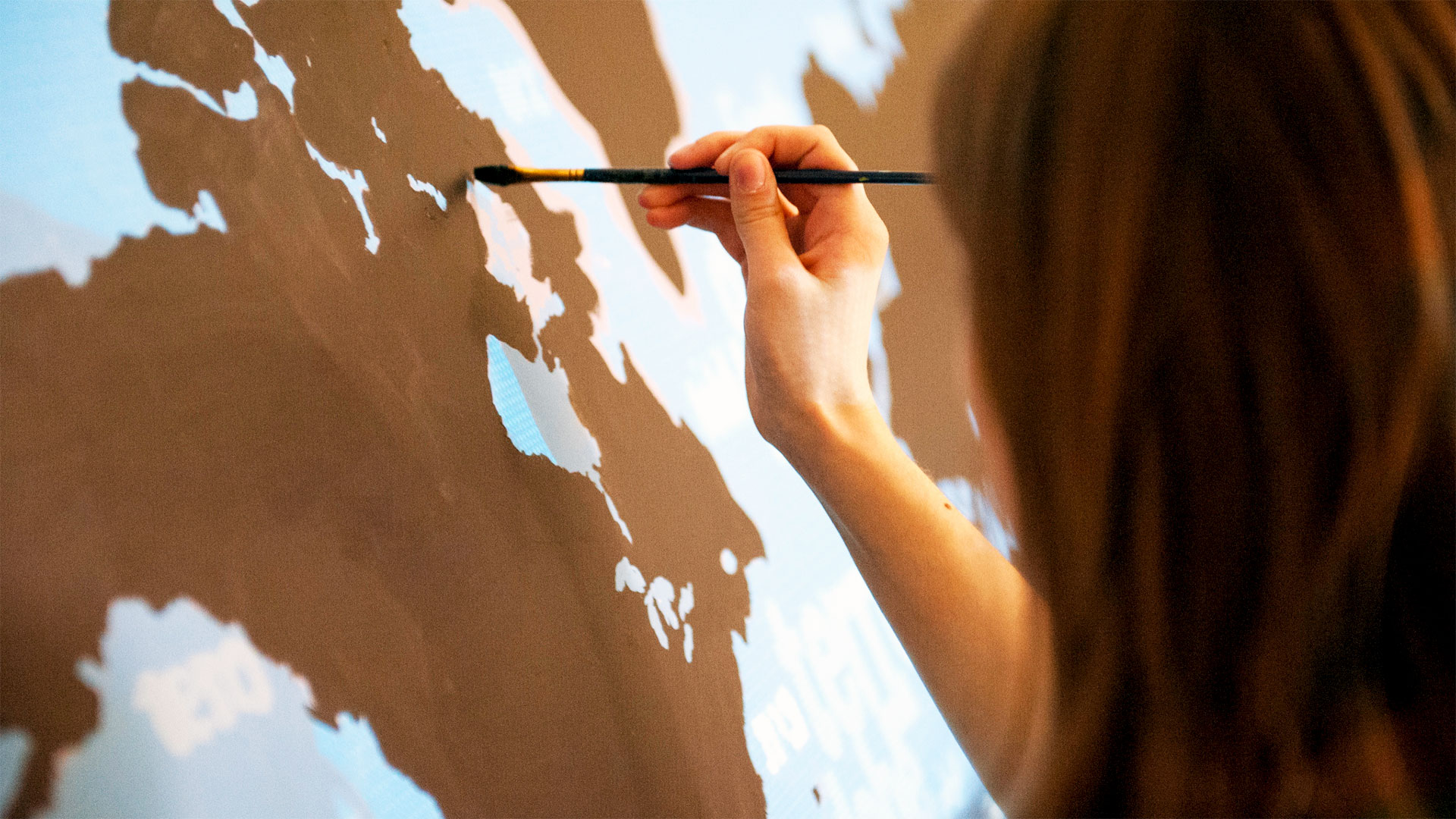 Scholar painting a mural in The GLOBE