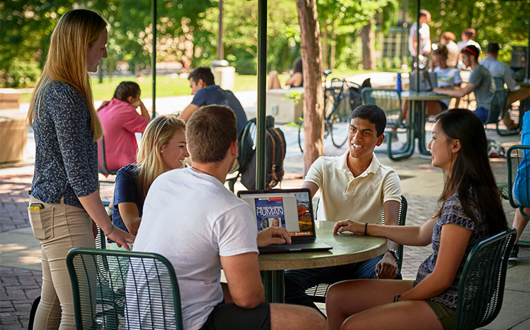 A group of Schreyer Scholars huddled around a laptop