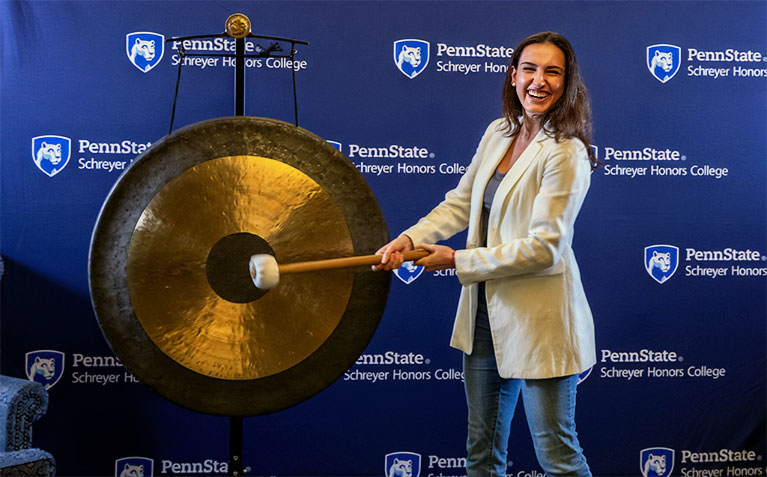 A Schreyer Scholar ringing the gong to celebrate the completion of their thesis
