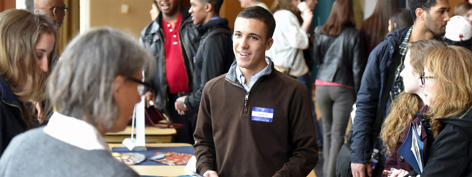 Prospective student visiting tables during Scholars Day
