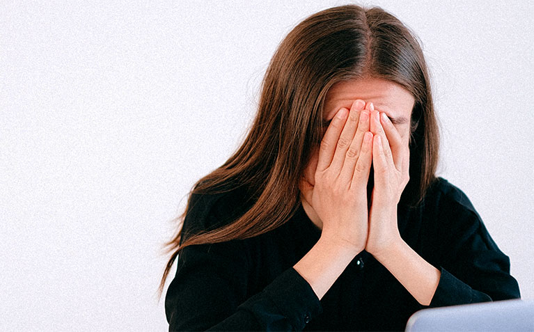 Stressed student with hands over her face