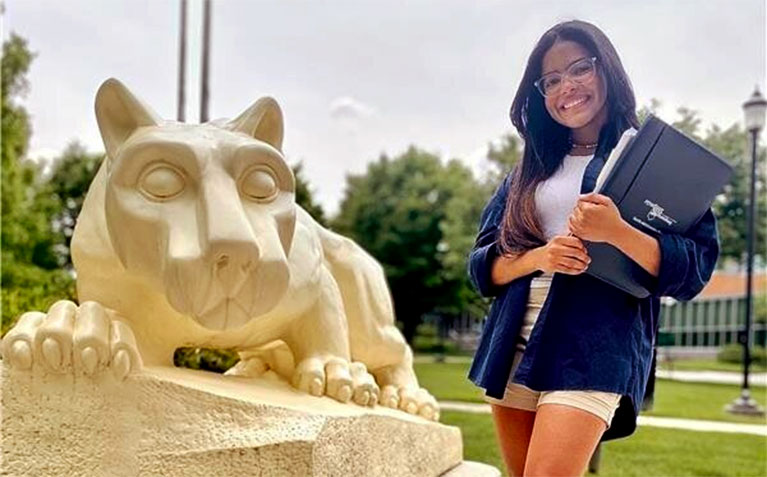 Schreyer Scholar Maria Hernandez posing next to the Lion Shrine