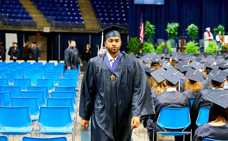 A Schreyer Scholar walking back to their seat after receiving their Scholars Medal