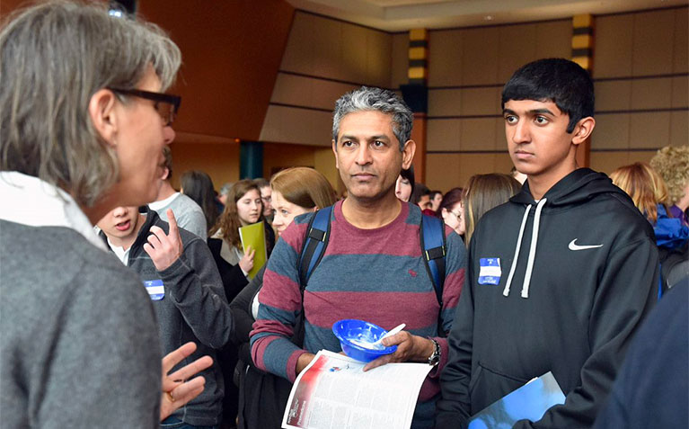 A future Schreyer Scholar and parent talking with staff during Scholars Day