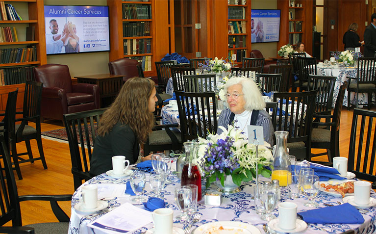 A Schreyer Scholar speaking with a distinguished alumna at the Society of Distinguished Alumni brunch