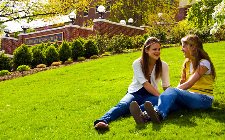 Scholars sitting in front of Atherton Hall