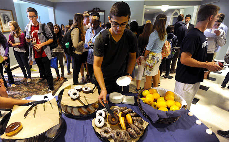 Scholar choosing a donut at Donuts with the Dean